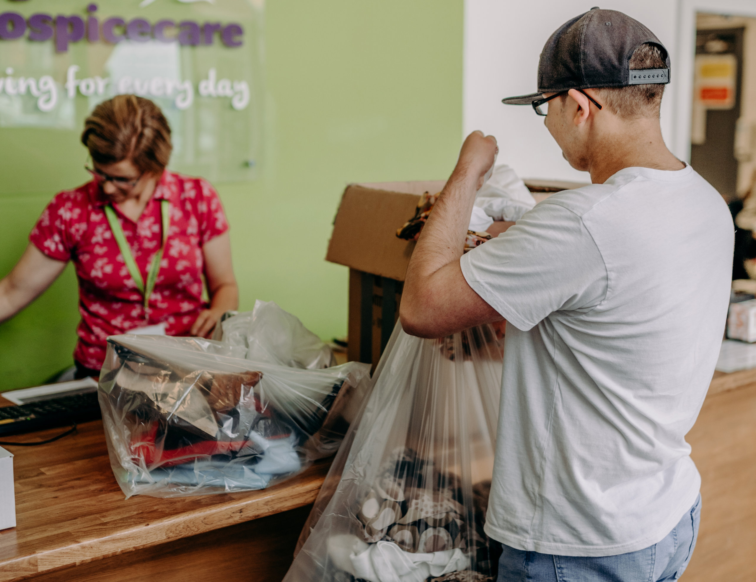 Man handing over a bag of donations at the donation centre