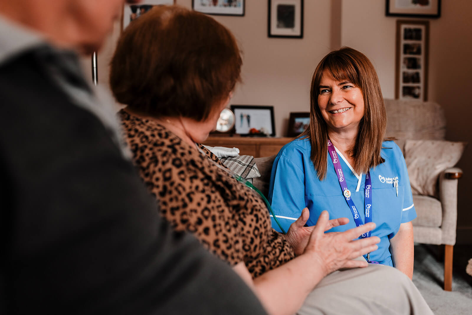 A palliative care support worker sitting with a family in their home