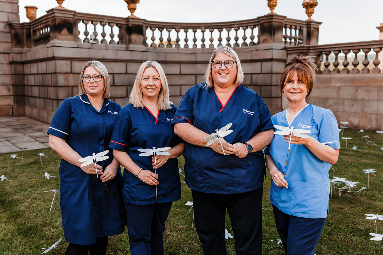 Nurses stood at Chatsworth each holding a stainless steel dragonfly