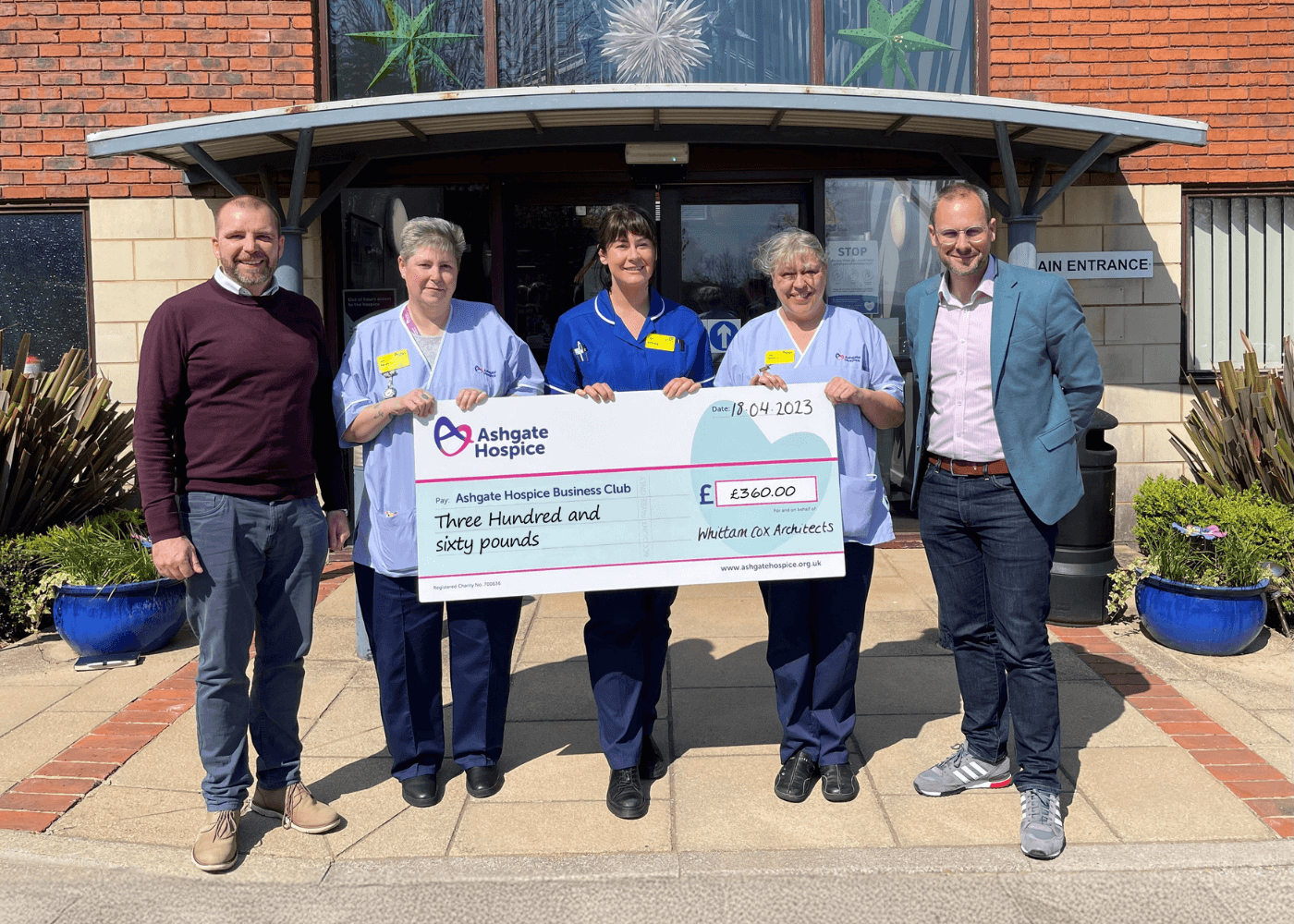 Group of people stood with a large cheque.