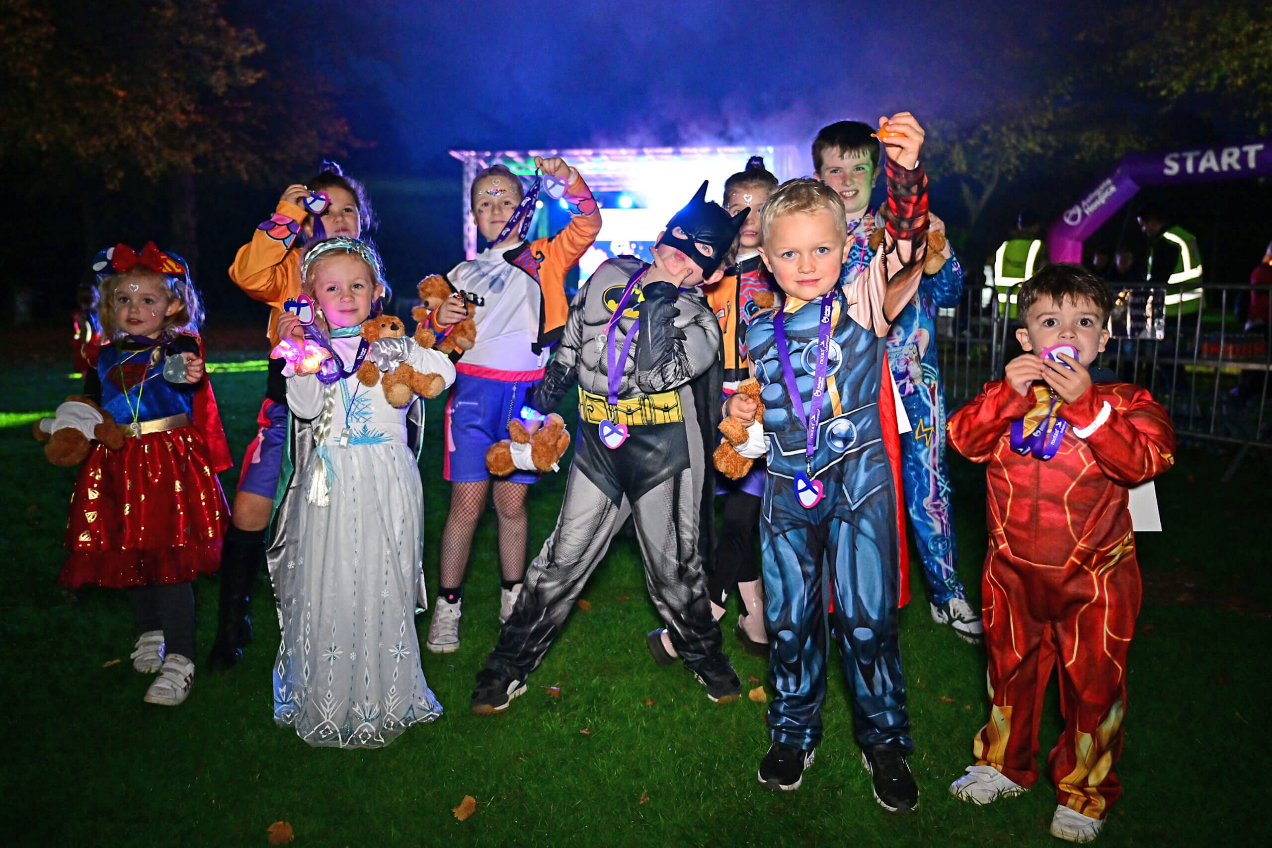 Kids in superhero costumes celebrating finishing Ashgate Hospice's Superhero Night Walk