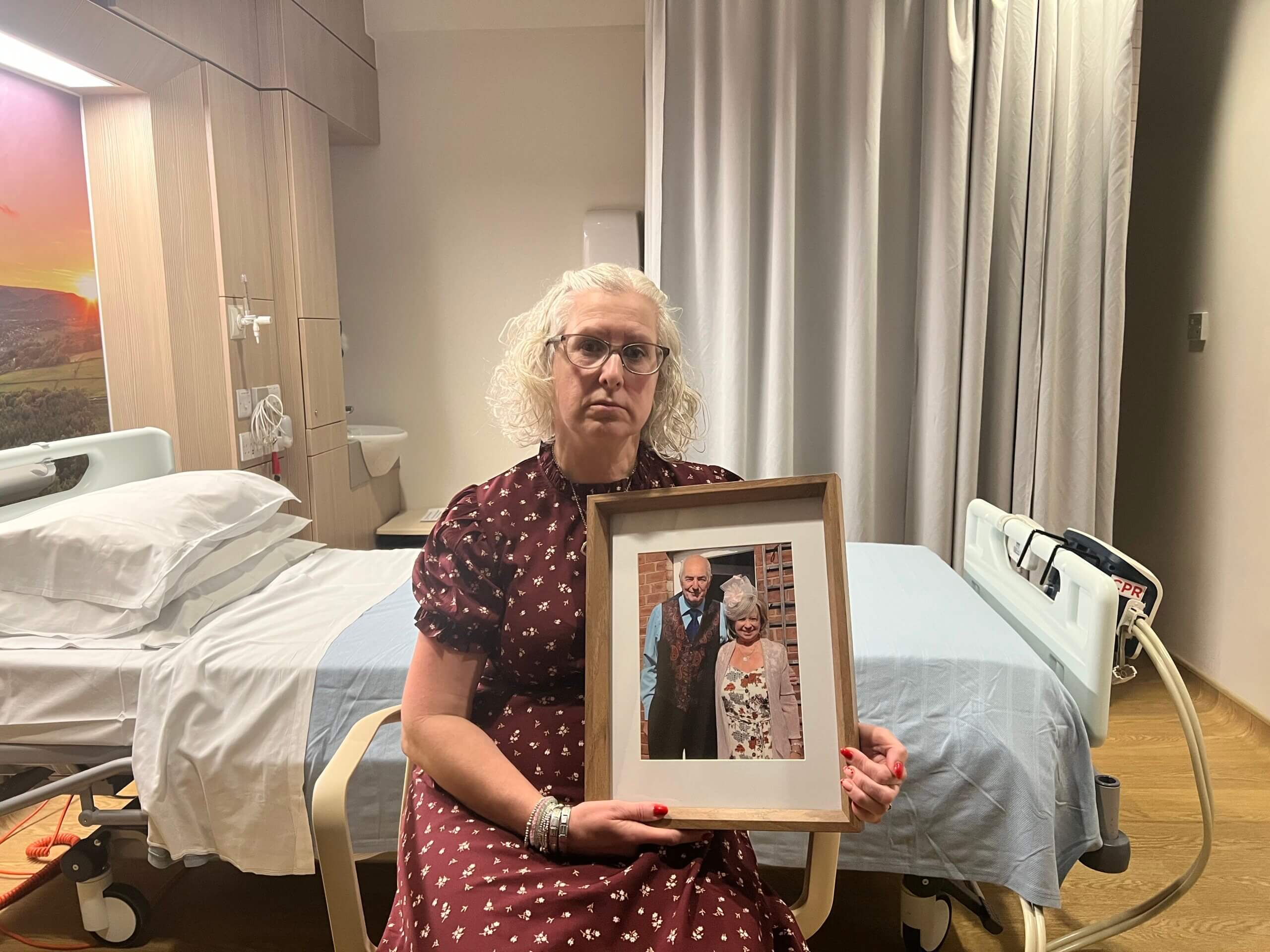 Woman in a hospice bedroom with a photo of her mum and dad